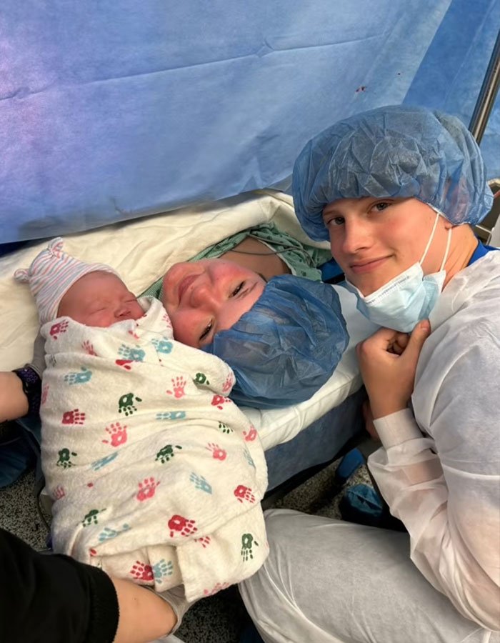 Mother in hospital bed with newborn baby and father wearing surgical caps, highlighting family impact of teen pregnancy.