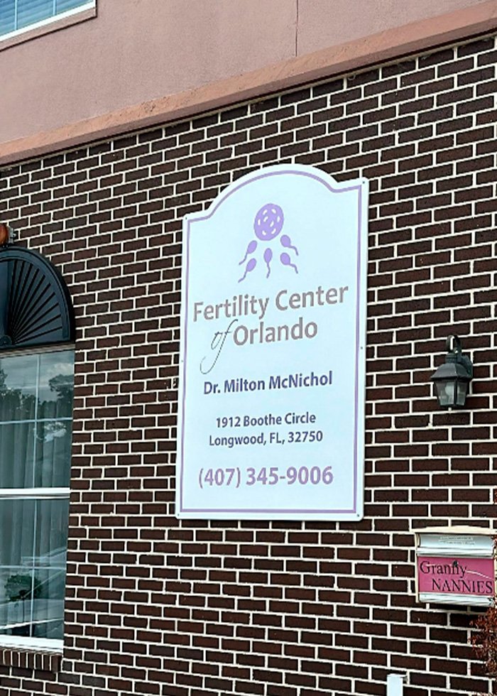 Sign for Fertility Center of Orlando on brick wall, related to parents suing fertility clinic after shocking mix-up.