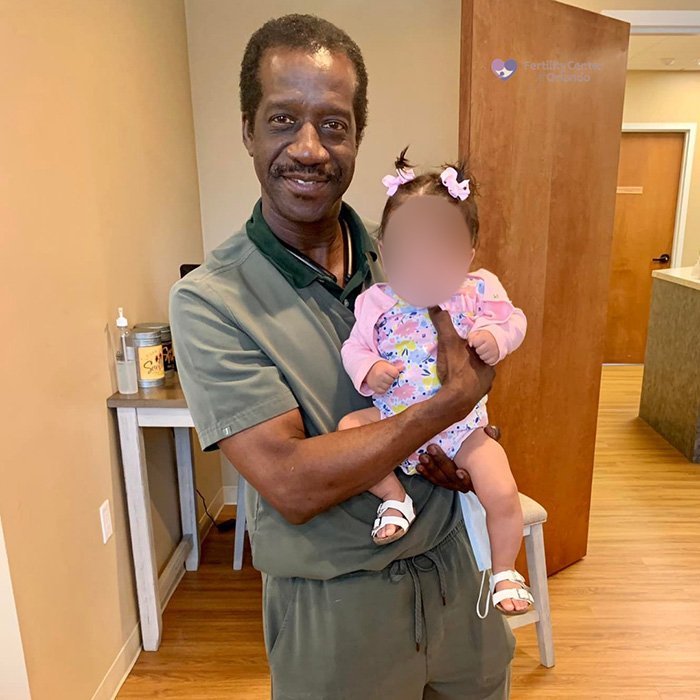 Man holding a baby in a fertility clinic setting, representing a shocking mix-up at a fertility clinic case.