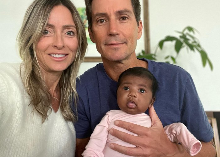 Couple holds a baby in their home after a fertility clinic mix-up leads them to deliver another couple's child.