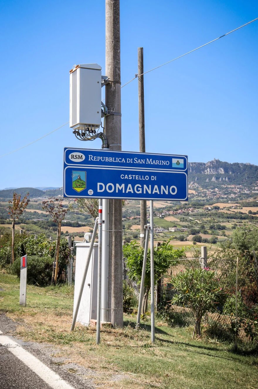 Road sign marking Castello di Domagnano in San Marino, one of 15 nations setting new global standards for paid leave