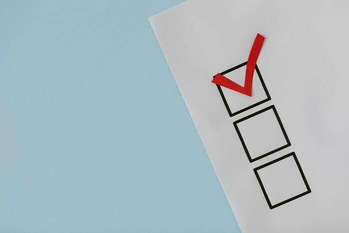Checklist with a red checkmark on white paper against blue background representing pub-style quiz questions.