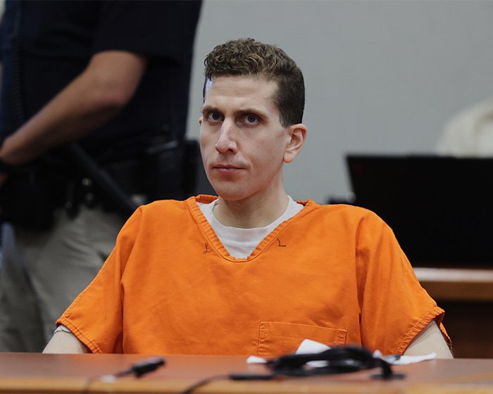 Bryan Kohberger in an orange prison jumpsuit seated in courtroom during hearing related to disturbing victim autopsy details.