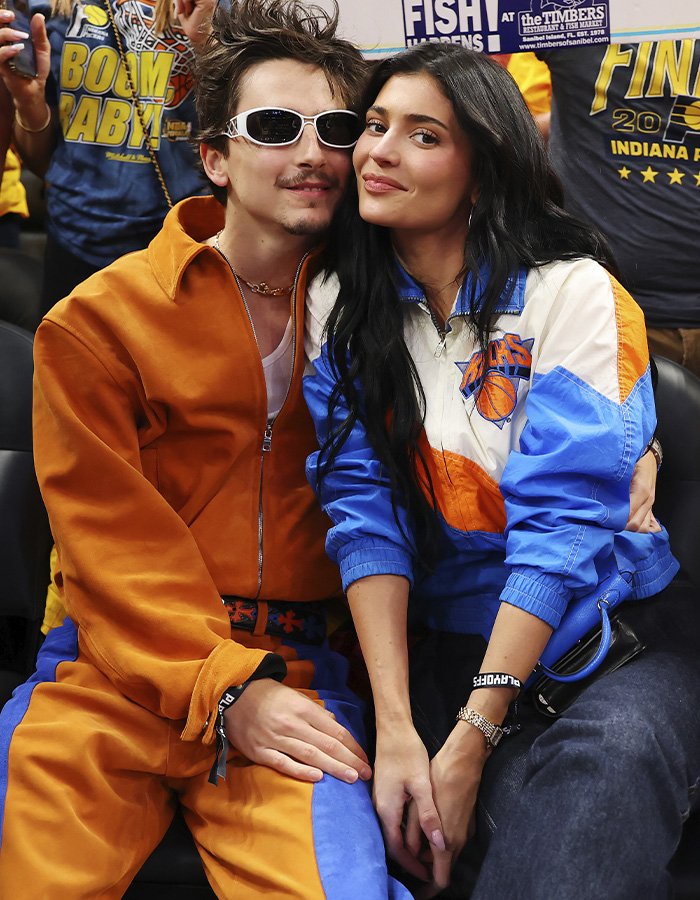 Timothée Chalamet and Kylie Jenner sitting close together at a sports event, sparking buzz with their outing.