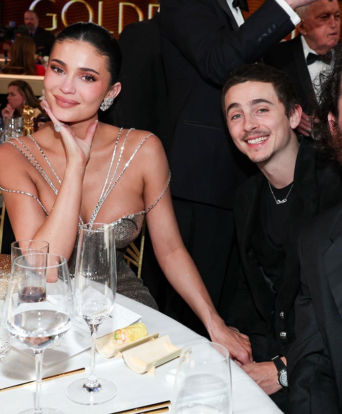 Kylie Jenner and Timothée Chalamet seated at a formal event, highlighting their Golden Globes connection and recent fight exposure.