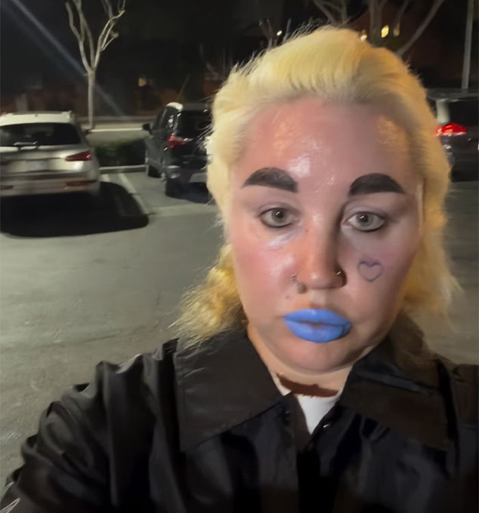 Amanda Bynes with new tattoo on face, bright makeup, highlighting tragic tale of child stars in a nighttime parking lot.