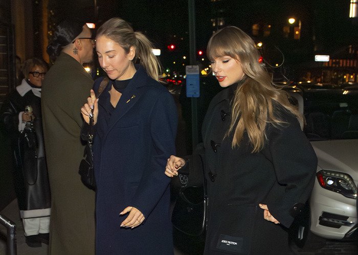 Taylor Swift leaving a friend's wedding in a dark coat, outfit scrutinized by fans for trying to upstage the bride at night.