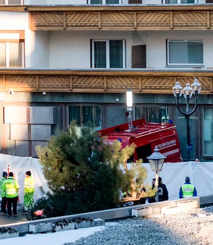 Emergency responders and police at the scene near a Swiss bar with fire trucks after escape of waitress from fire incident.