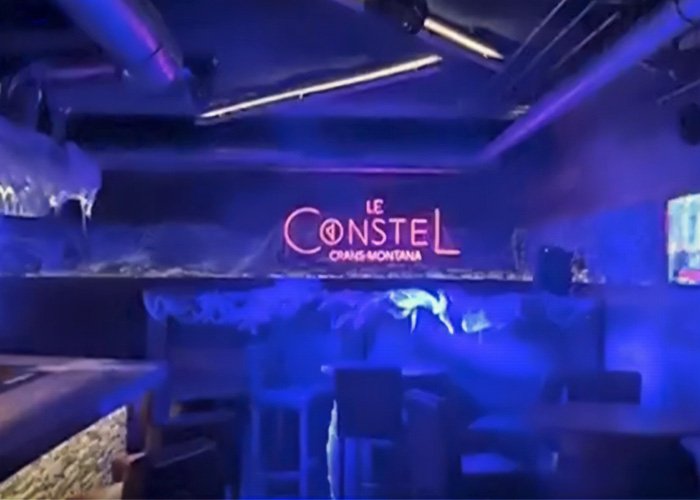 Interior of a dimly lit Swiss bar with neon signs where a waitress escaped a tragic fire incident.