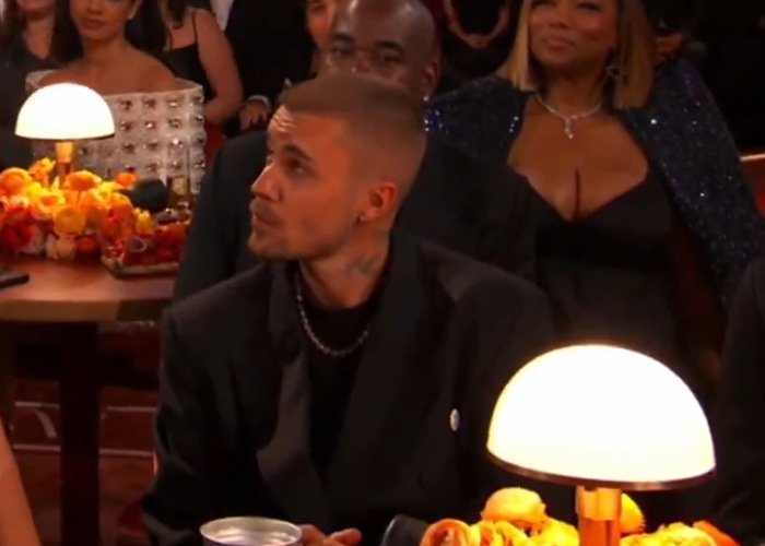 Man with a serious expression in a dark suit at an event, body language expert decodes tense behavior.