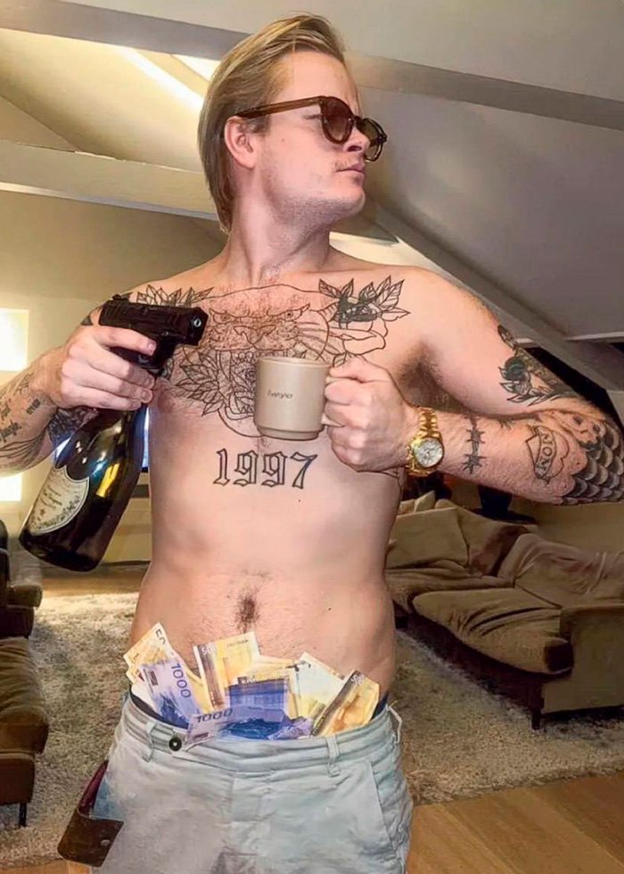 Shirtless young man with tattoos holding a gun, bottle, and cup, with cash stuffed in his pants, court and jail concept.