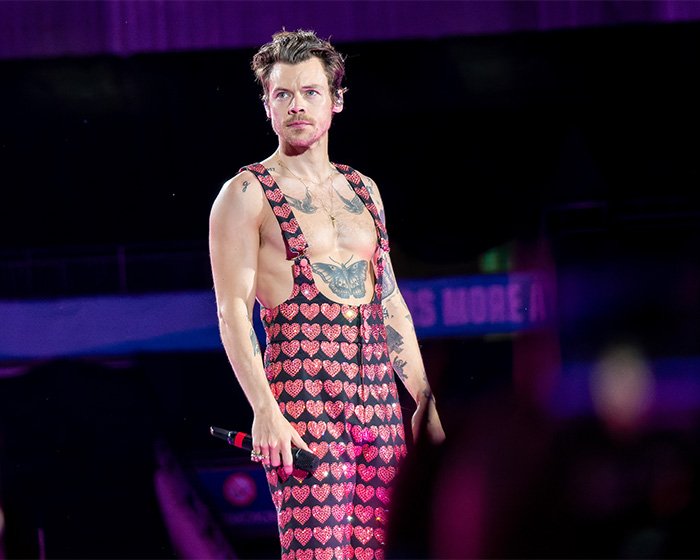 Harry Styles on stage wearing heart-patterned outfit during Grammys performance, sparking outfit criticism.