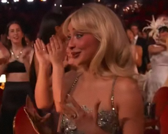 Sabrina Carpenter reacting emotionally at an event, capturing the moment of her Grammy losses leaving fans moved.