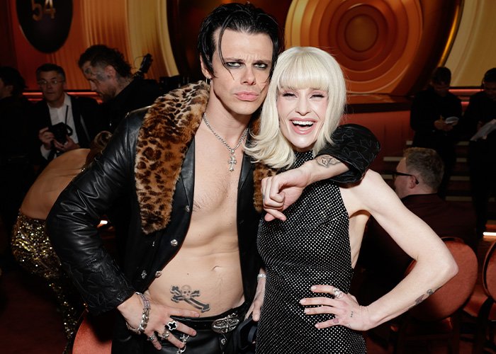 Kelly Osbourne with a fan at an event, showing an odd detail that sparked fan concern about her health.