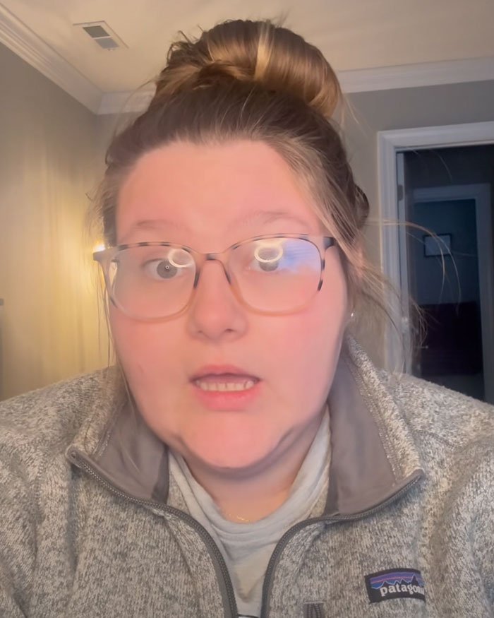 Young woman wearing glasses and a Patagonia jacket, sharing her story as a vet tech involved in dog rescue during snowstorm.
