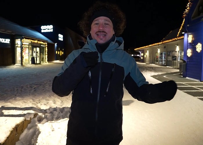 Content creator standing outside at night on the world’s darkest island, dressed warmly in winter clothing.