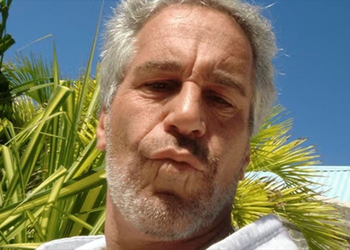 Close-up of a man with gray hair and beard outdoors near palm trees, linked to Epstein files in viral news coverage.