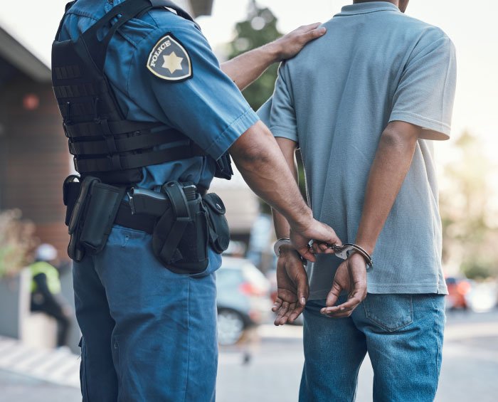 Police officer handcuffing a man outdoors, illustrating creepy dad trying to lie his way out of trouble and ending in jail.
