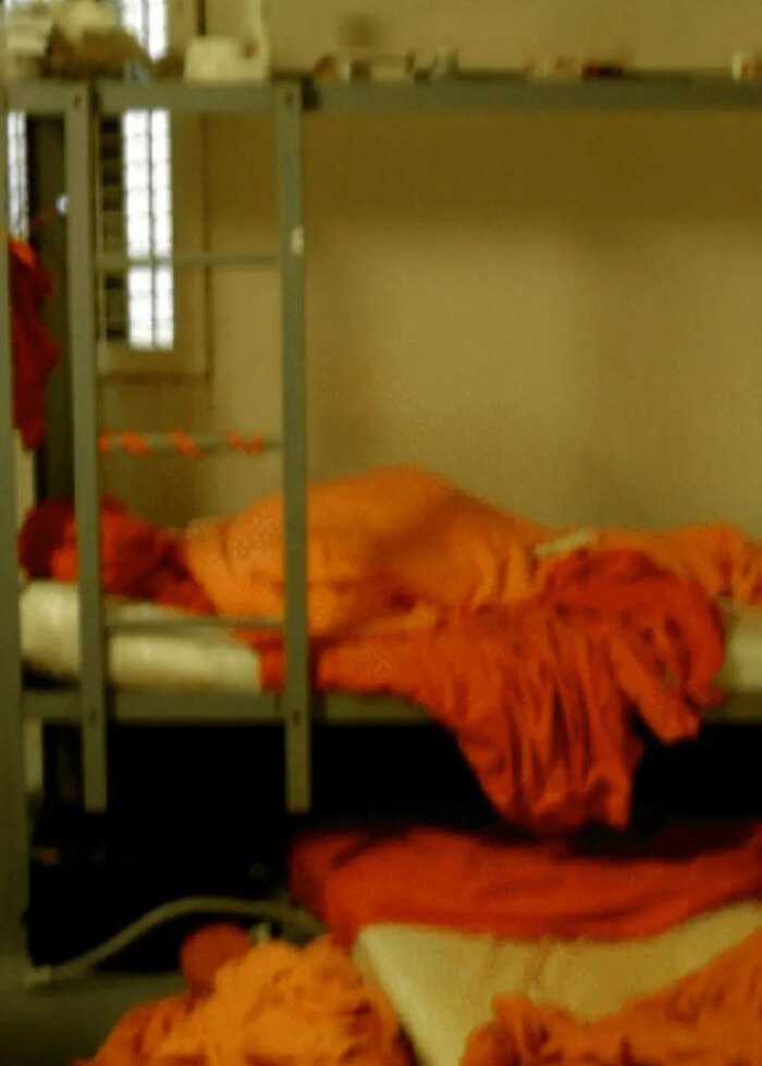 Blurry image of a prison bunk bed with orange blankets symbolizing viral theory claims Epstein may still be alive Fortnite connection