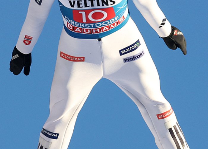 Close-up of an athlete wearing a white suit in midair, related to injecting hyaluronic acid into the body amid Olympic controversy.