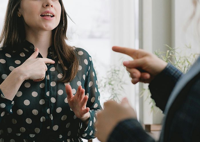 Teen and stepmom arguing indoors, tense moment capturing conflict over late mom’s memory on wedding day.