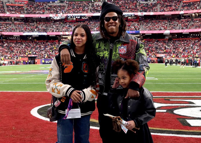 Jay-Z with Blue Ivy and family at the Super Bowl, showcasing Blue Ivy’s striking resemblance to her mom Sparks fans.