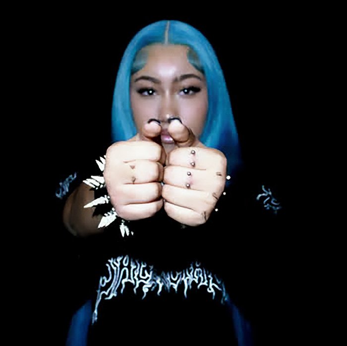 Person with blue hair showing recent piercings on hands, highlighting disturbing development noticed by fans.