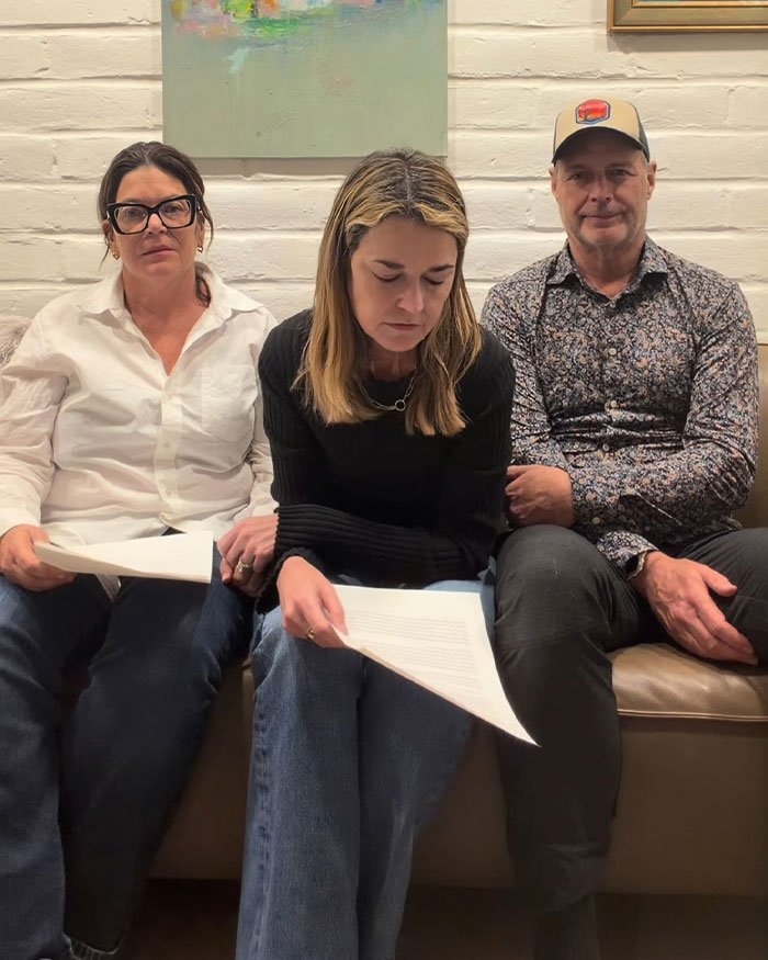 Three people sitting on a couch holding papers, discussing the FBI official's update on Nancy Guthrie's disappearance.
