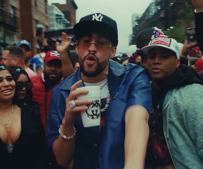 Bad Bunny performing in a crowd with fans reacting, highlighting heated debate over explicit lyrics translation.