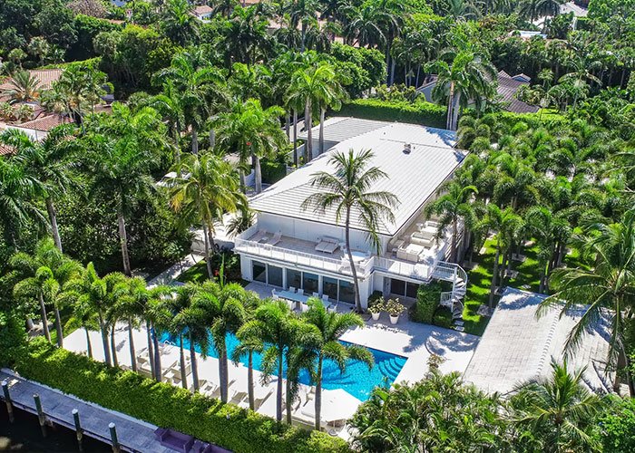 Aerial view of a luxury estate surrounded by palm trees and a pool, related to Trump Epstein investigation FBI documents.