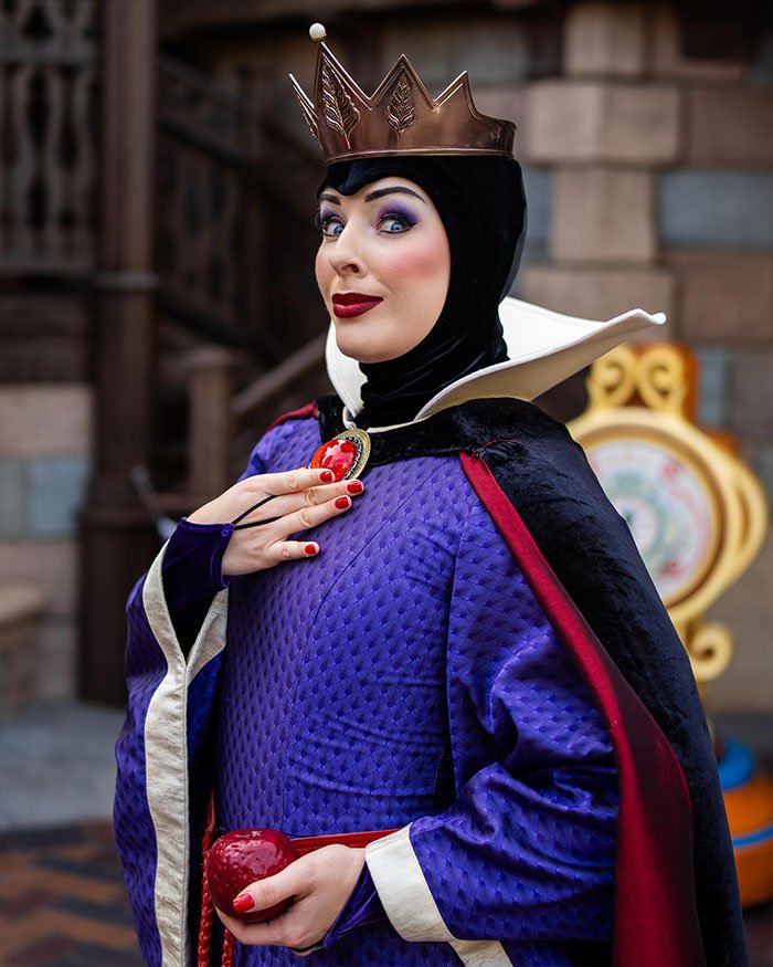 Ex-Disneyland Evil Queen in costume holding a red apple, showcasing her look before the controversial firing.