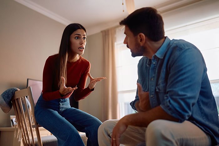 Couple having an intense argument in a room, illustrating a man’s marriage on the rocks over his 12-year-old daughter secret.