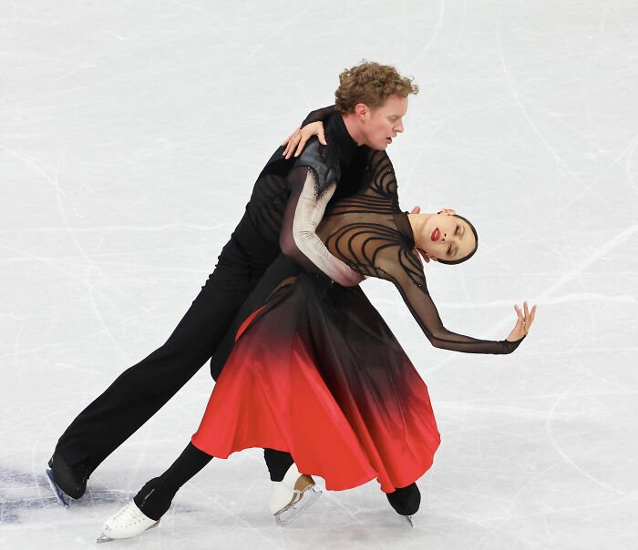 Figure skating Olympian performs dramatic dance pose amid cheating accusations and judge's controversial scores.