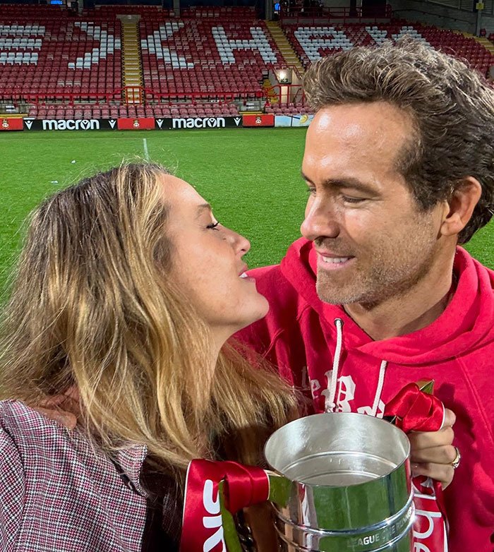 Blake Lively and Justin Baldoni sharing a moment at a stadium holding a trophy, showcasing a fashion faux pas.