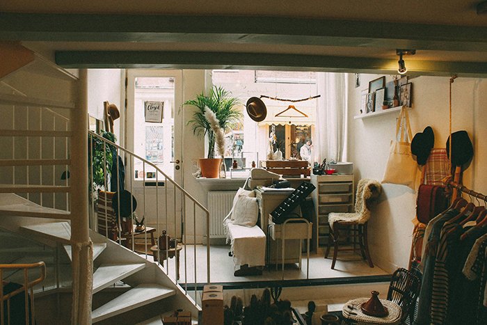 Cozy new parents’ home with seating, plants, and clothing racks, reflecting concerns raised by in-laws about living conditions.
