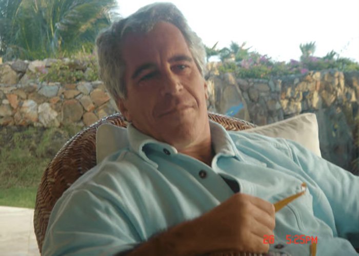 Jeffrey Epstein sitting outdoors in a light blue shirt, relaxing with a tropical background, related to obsession reports.