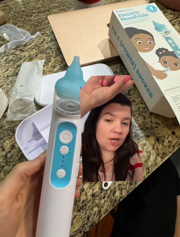 Hand holding Frida Mom electric nose suction device with packaging on kitchen counter, woman explaining product.
