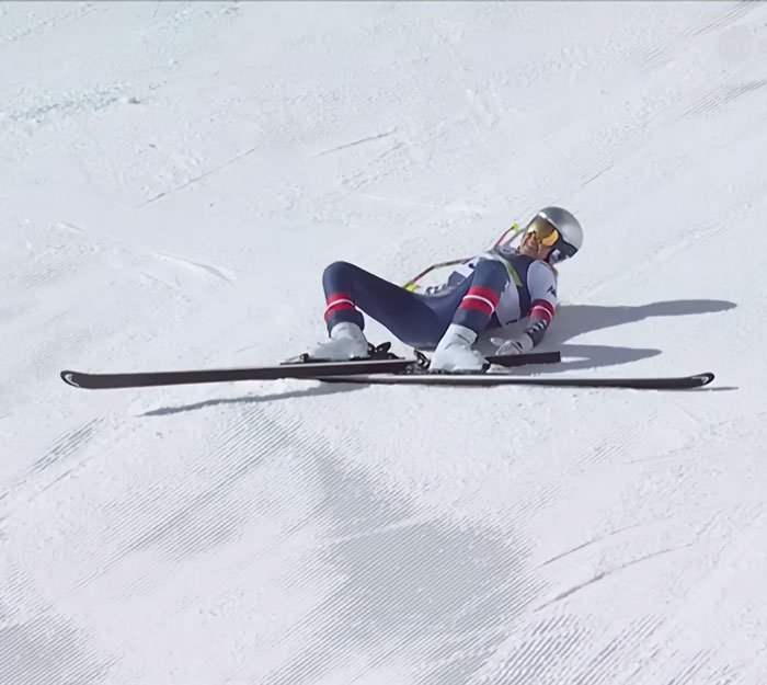 Skier Lindsey Vonn lying on snowy slope after Olympics accident, facing backlash following major life update.