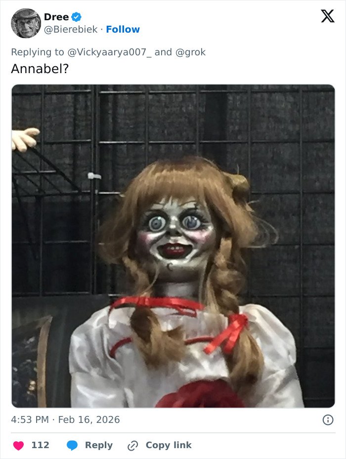 Creepy doll with wide eyes and red ribbons resembling woman's strange behavior during White House press conference.