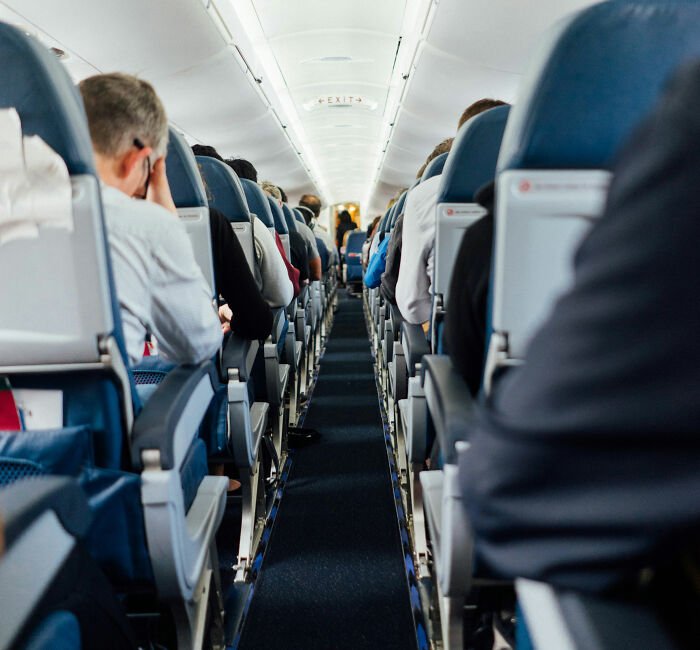 Airplane cabin interior with passengers seated, highlighting Southwest seating policies and toddler separation issues.