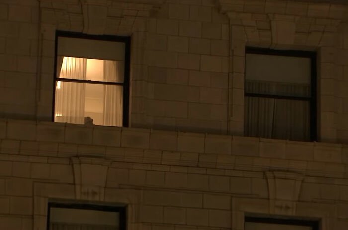 Window of a ritzy hotel at night with soft yellow light visible inside, relating to Tommy Lee Jones’ daughter’s cause of passing.
