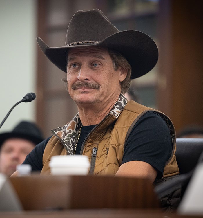Man in cowboy hat and brown vest sitting indoors, related to RFK Jr. workout video sparking wild reactions.