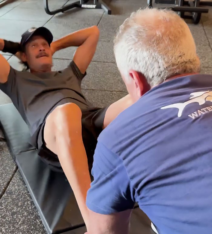 RFK Jr. and Kid Rock performing a workout exercise together on a gym floor, sparking wild reactions.