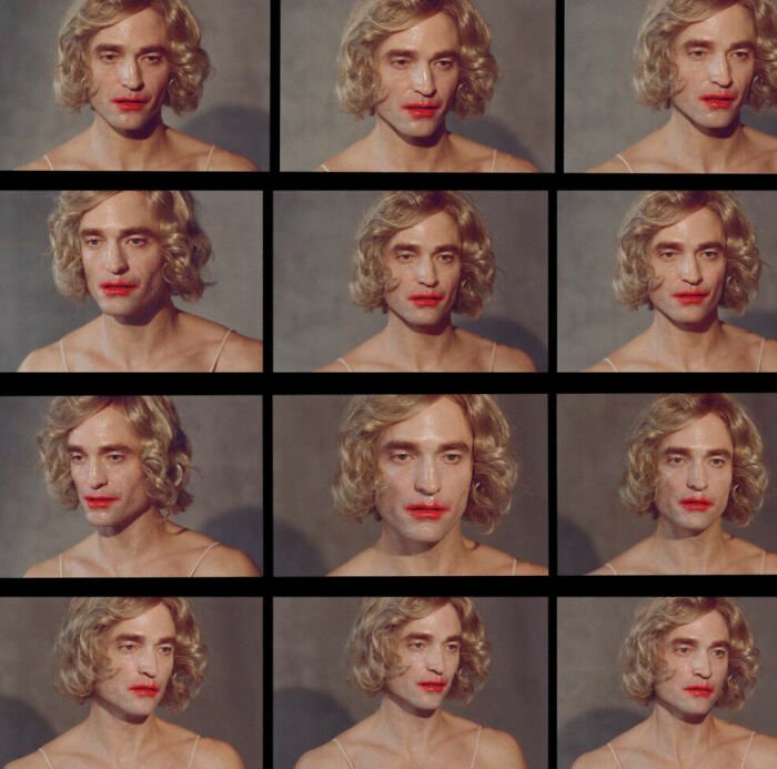 Robert Pattinson in a gender-bending photoshoot wearing a blonde wig and red lipstick, creating an extremely disturbing vibe.