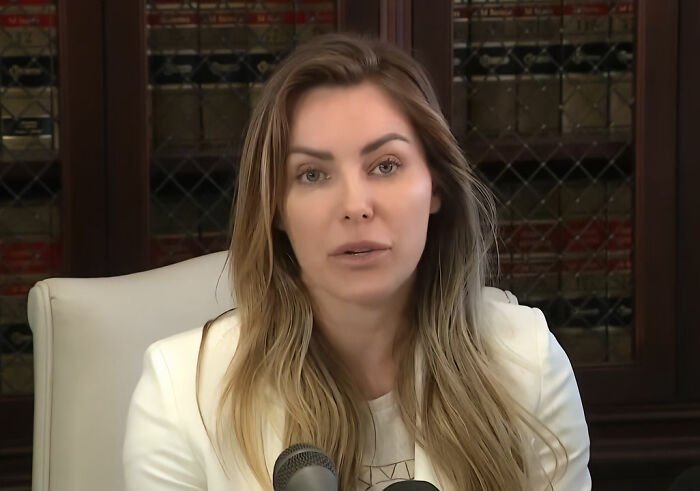 Woman speaking at a press conference, discussing a bombshell claim about Playboy founder Hugh Hefner.
