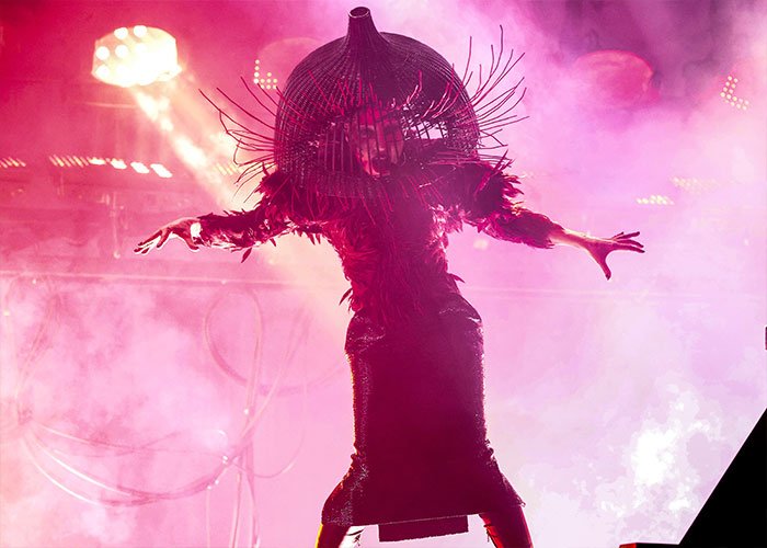 Lady Gaga in a striking, scary outfit with elaborate headpiece and dramatic mannerisms at a recent concert performance.