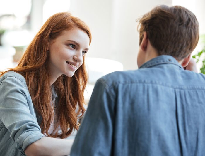 Woman with red hair talking to a man, symbolizing a woman realizing her late brother's baby isn’t his after testing suspicions.