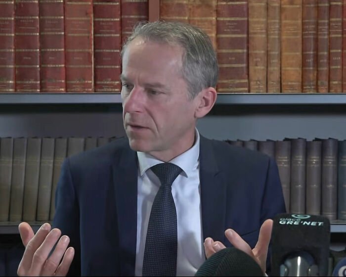Male lawyer in a suit speaking during a press conference about a teacher accused of crimes against under-privileged students