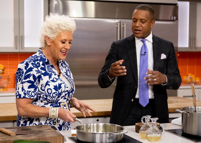 Anne Burrell in a kitchen setting with a man in a suit, preparing food while discussing details related to police reports.