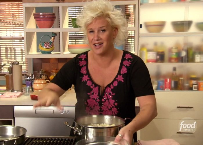 Chef Anne Burrell cooking in a kitchen, featured in a police report revealing alleged tragic details of her passing.